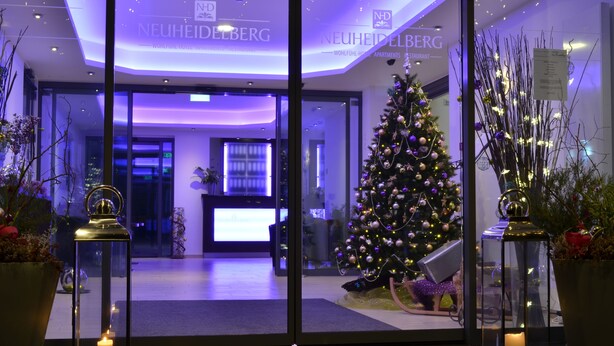 A hotel entrance with a Christmas tree, a reception desk, and a modern interior design. - Wohlfühl - Hotel Neu Heidelberg - Hotel Heidelberg (Heidelberg)