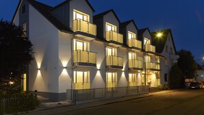 A multi-story hotel with balconies, a well-lit entrance, and a street view. - Wohlfühl - Hotel Neu Heidelberg - Hotel Heidelberg (Heidelberg)