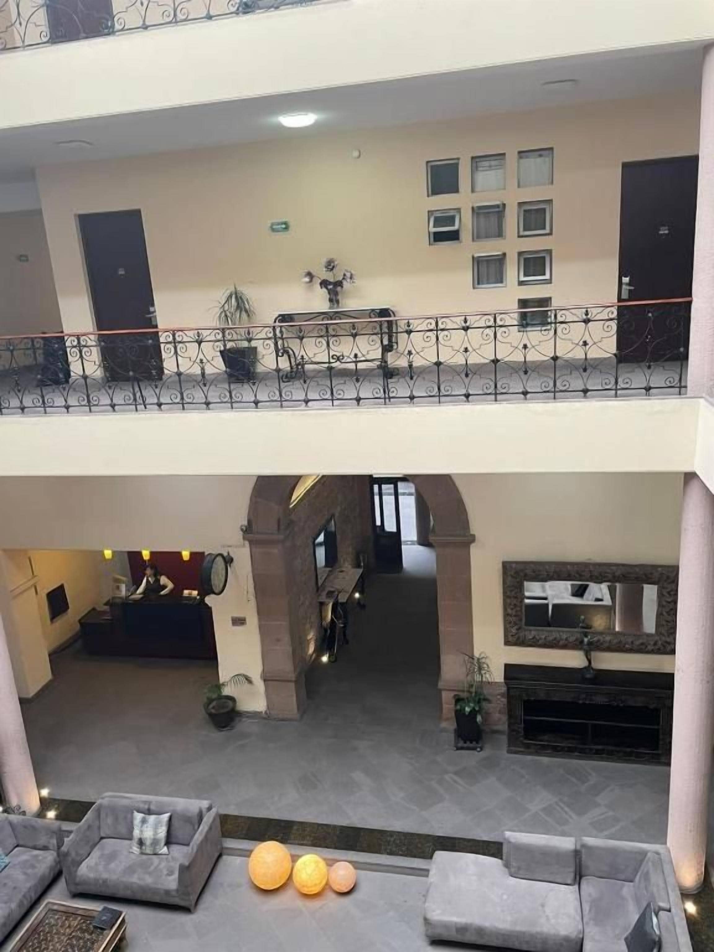 Un vestíbulo de hotel con varios niveles, una recepción, una zona de estar y una chimenea.