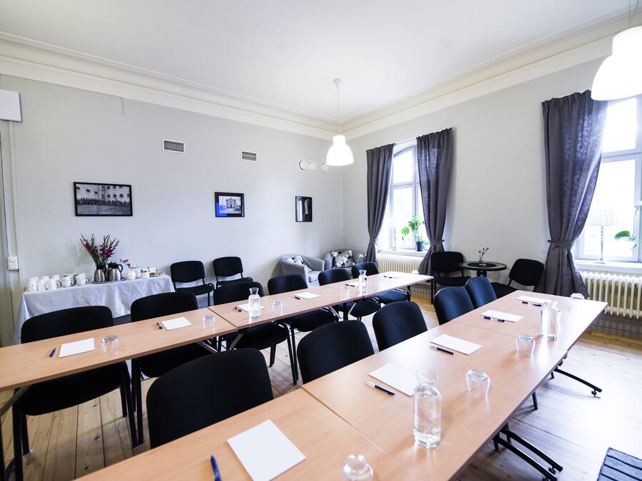 A conference room with a long table, chairs, and a whiteboard.