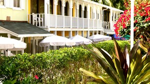 A two-story building with a balcony, white railings, and outdoor umbrellas. - Sunrise Beach Club and Villas (Paradise Island)