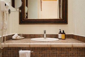 Ein Badezimmer mit Waschbecken, Spiegel und Toilettenartikeln.