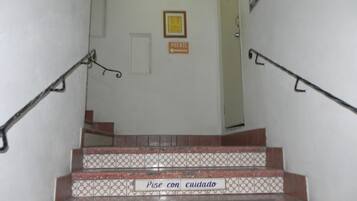 Una escalera con barandillas y peldaños marcados con instrucciones de seguridad en español e inglés.