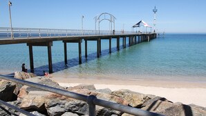 Un muelle se adentra en aguas tranquilas bajo un cielo despejado.