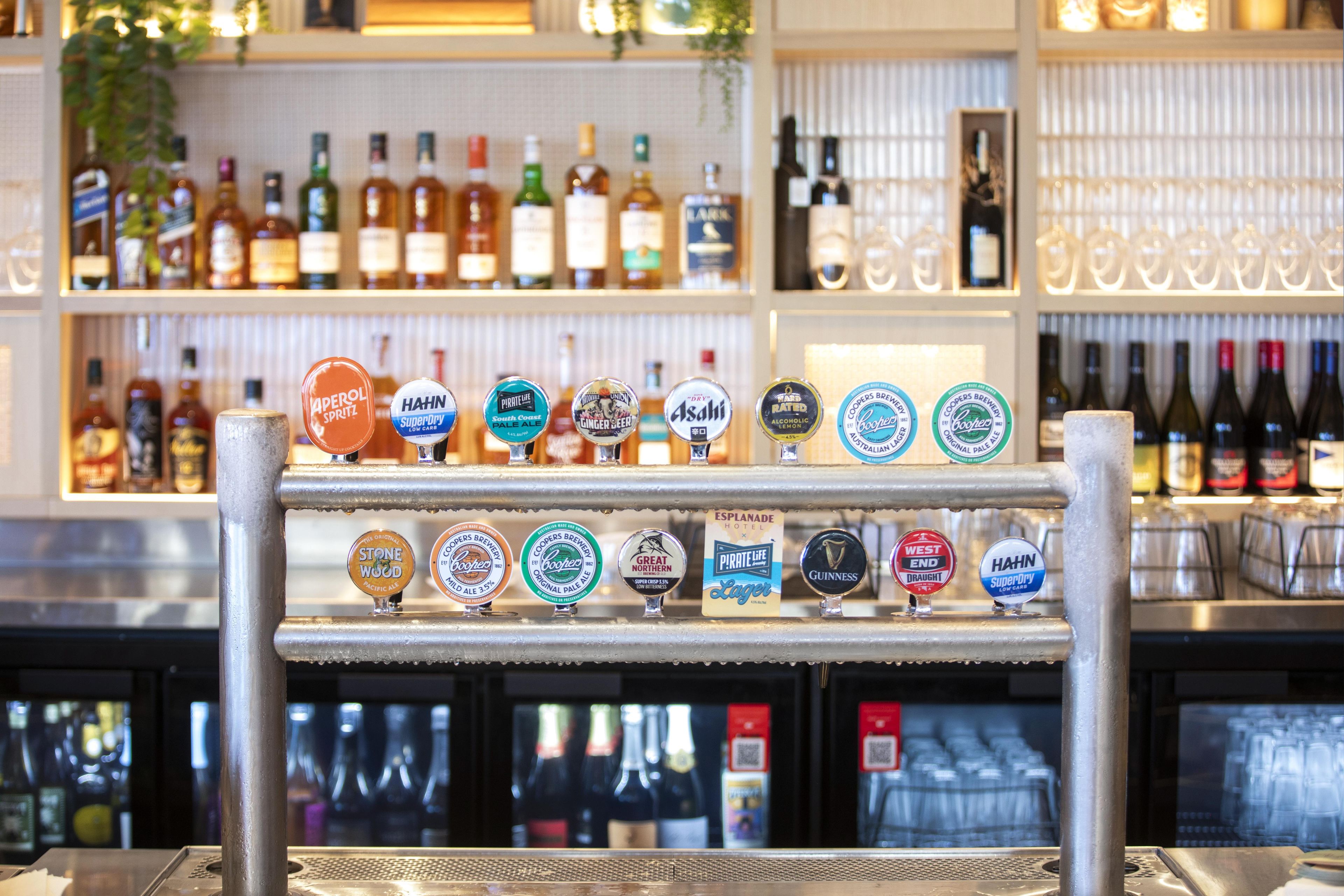 Zona de bar con un mostrador de grifos que exhibe diferentes marcas de cerveza.