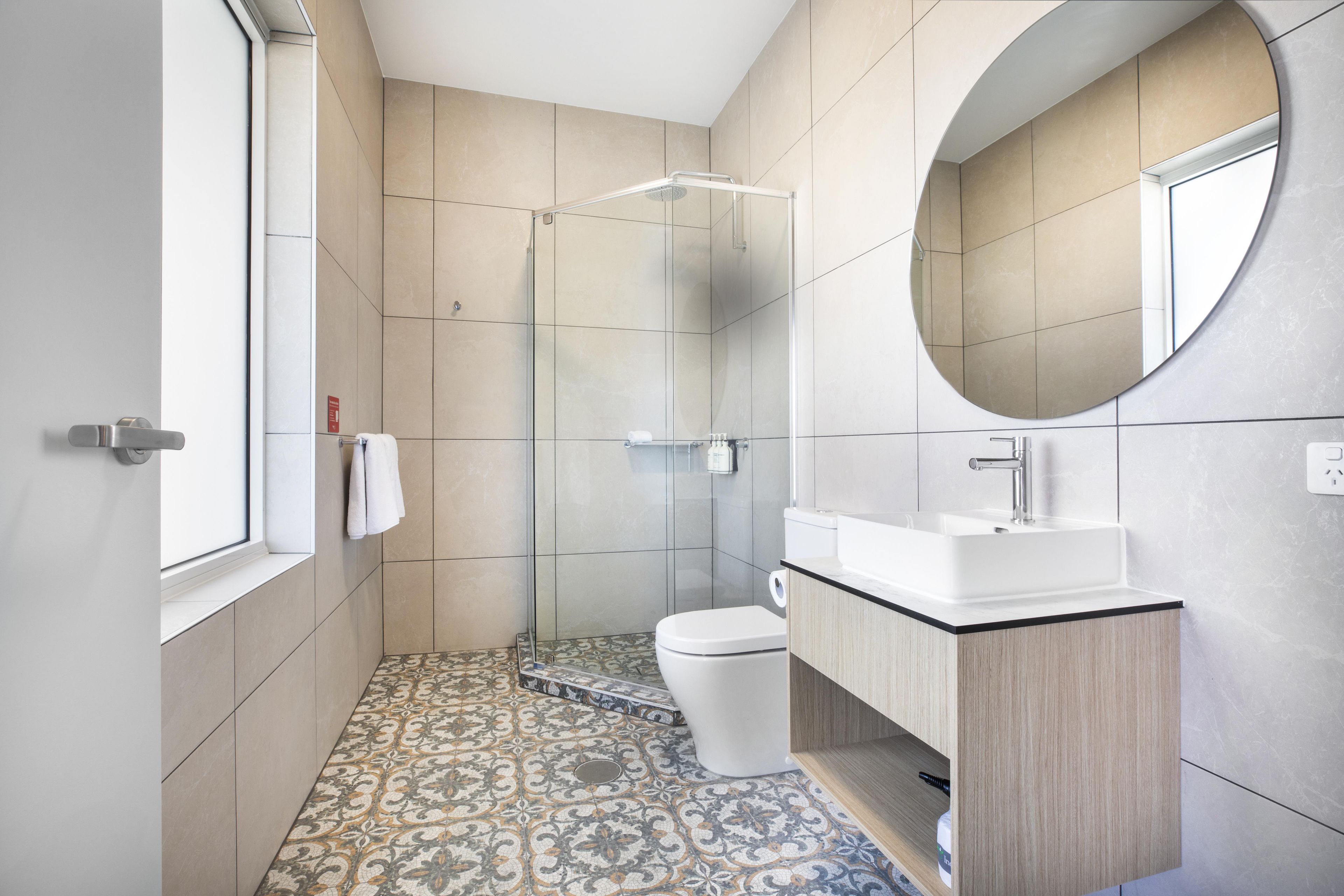 Une salle de bain moderne équipée d’une douche, de toilettes et d’un lavabo.