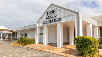 A FOOD POKIES SPORTS BAR with a covered entrance and a parking lot.