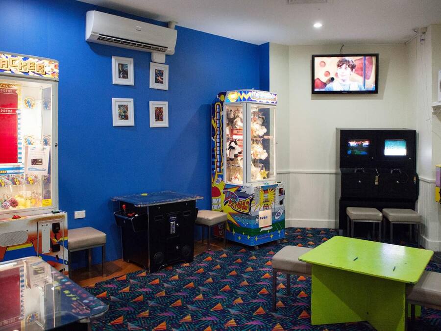 A room with arcade games, a television, and a patterned carpet.