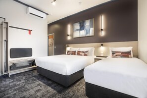 A hotel room with two beds, a desk, a chair, a wardrobe, and a large abstract painting on the wall. - Nightcap at Wanneroo Tavern (Wanneroo)