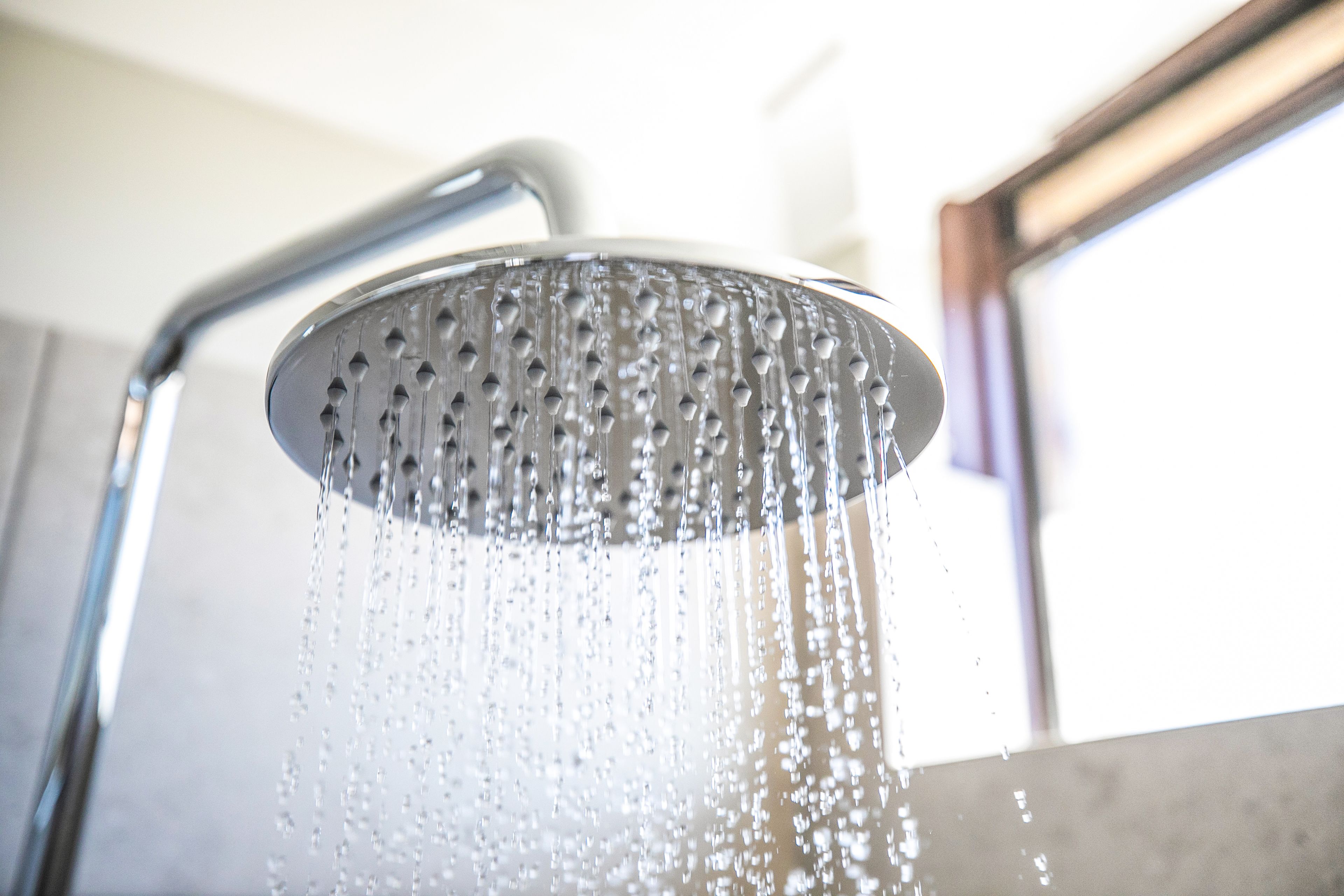 A showerhead with water flowing from it.