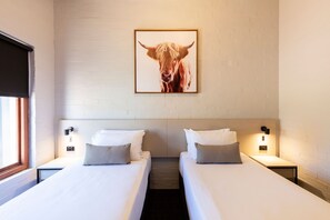 A hotel room with two beds, white bedding, a framed animal picture on the wall, and bedside lamps. - Nightcap at Wintersun Hotel (Bluff Point)