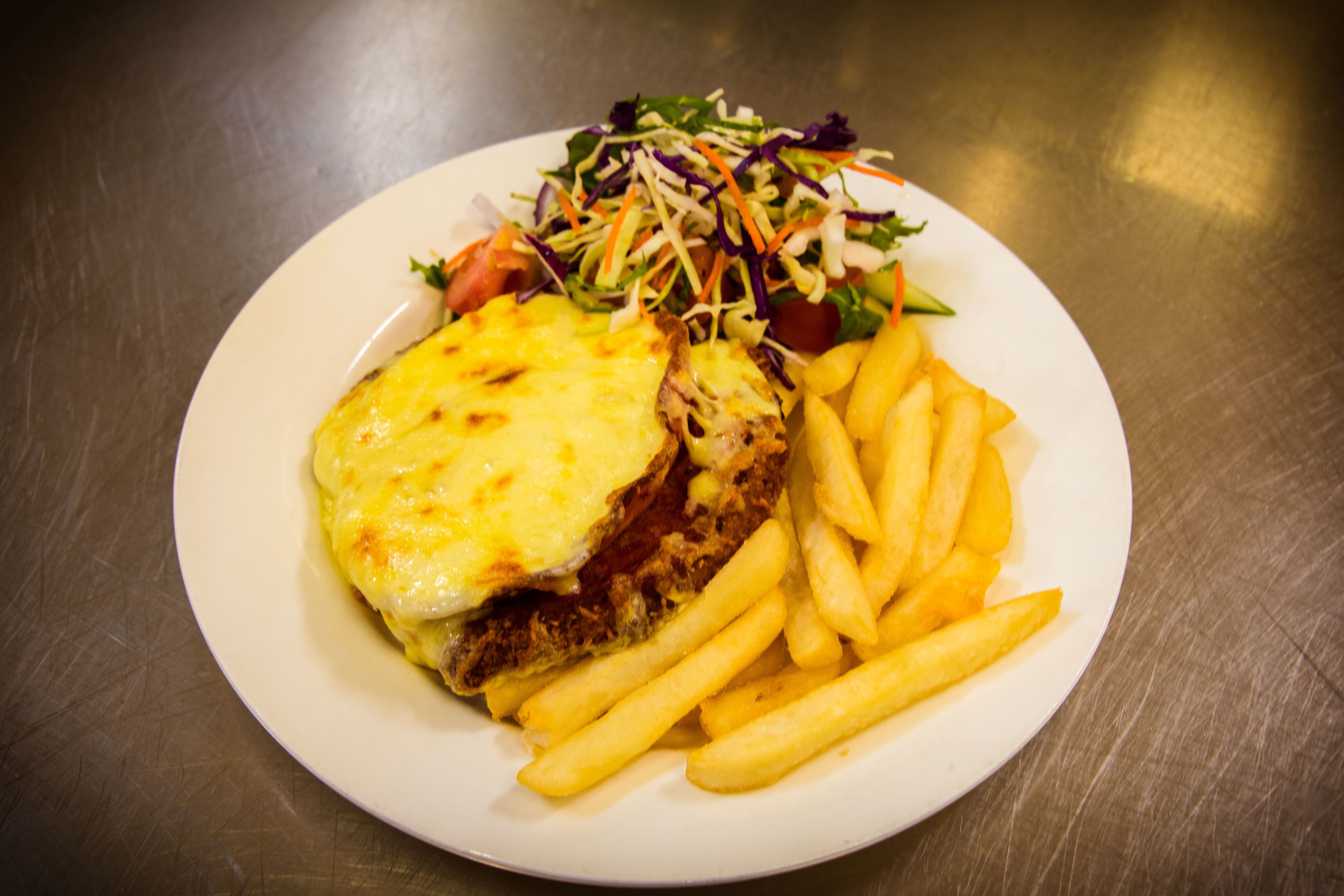 A plate with a sandwich, fries, and a salad.