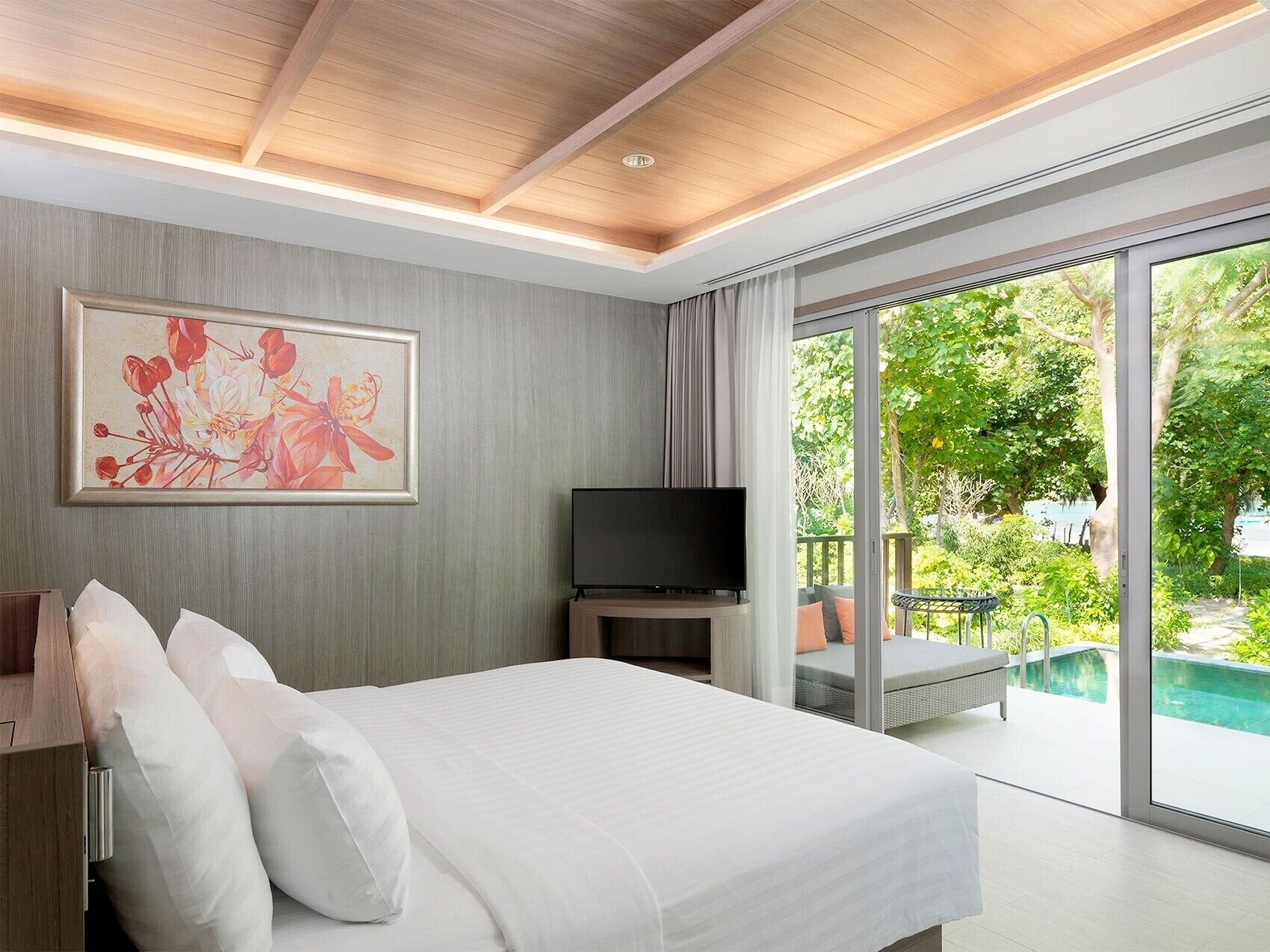 Une chambre d’hôtel moderne avec un grand lit, un téléviseur à écran plat et un tableau au mur.
