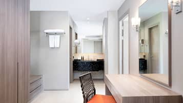 A modern bathroom with a vanity, a large mirror, and a shower area.