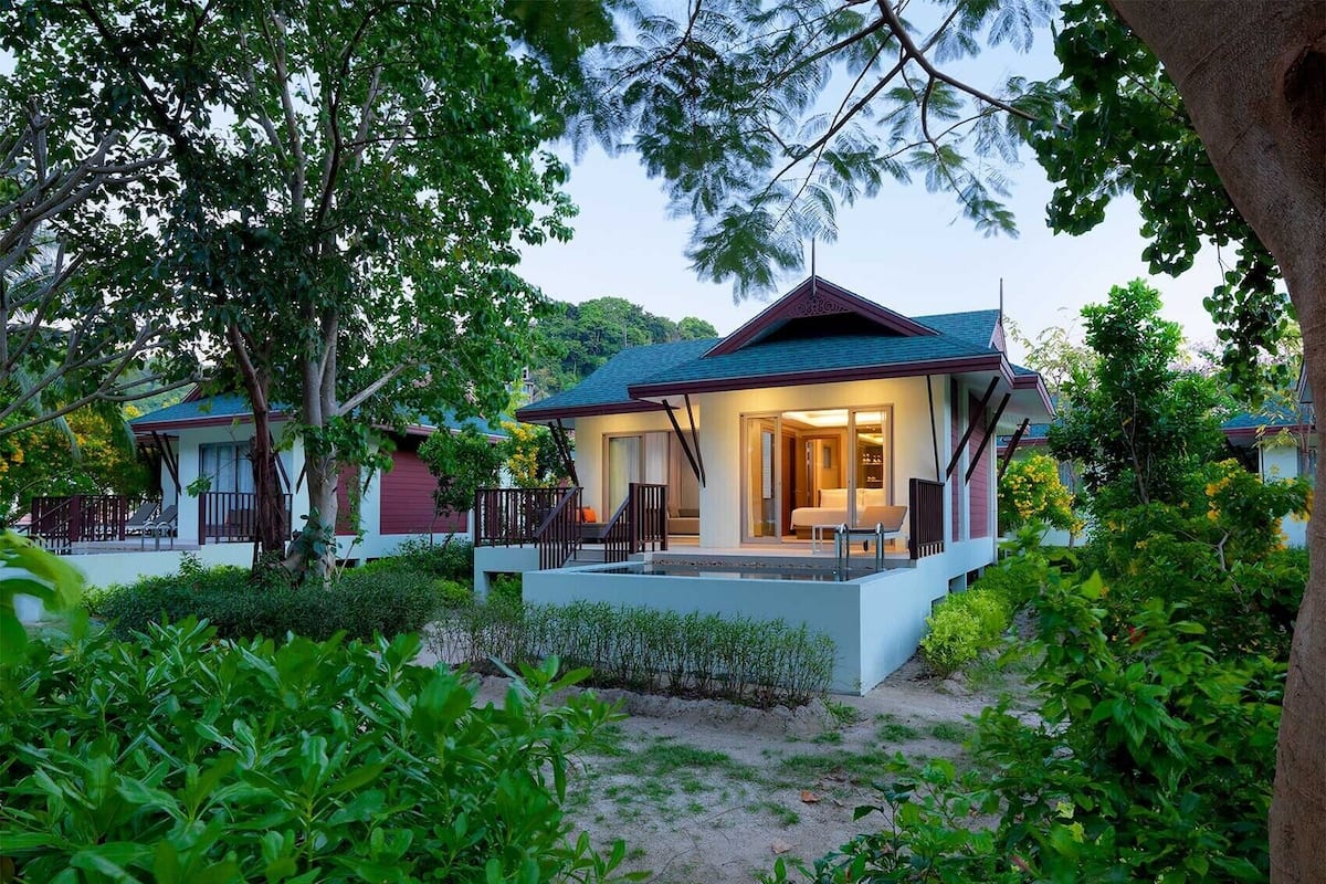 A resort with multiple villas, each featuring a balcony and a covered outdoor seating area.