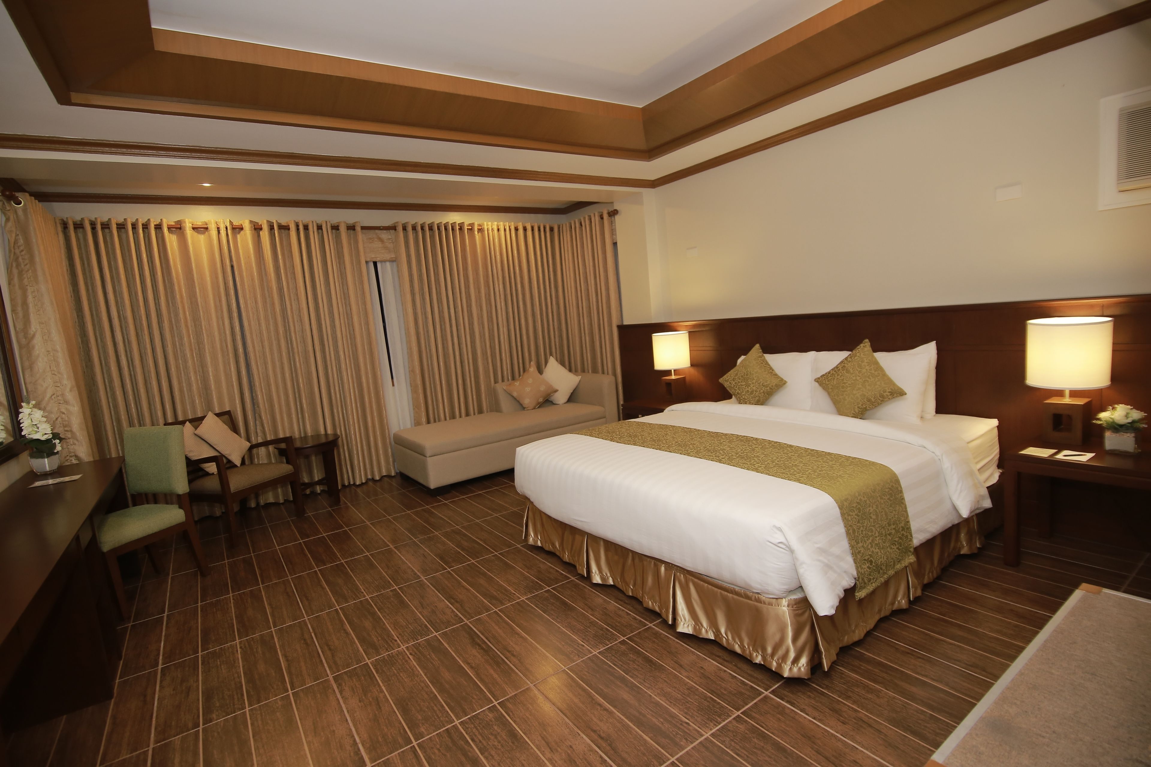 Une chambre d’hôtel avec un grand lit, un canapé, un bureau et une chaise.