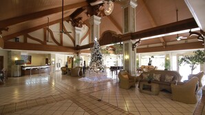 A spacious lobby with high ceilings, wooden beams, and a large Christmas tree. - The Suites at Mount Malarayat (Lipa)