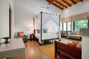 A bedroom with a four-poster bed, bedside tables, a chair, a sofa, and a dining table. - Wallawwa (Kotugoda)