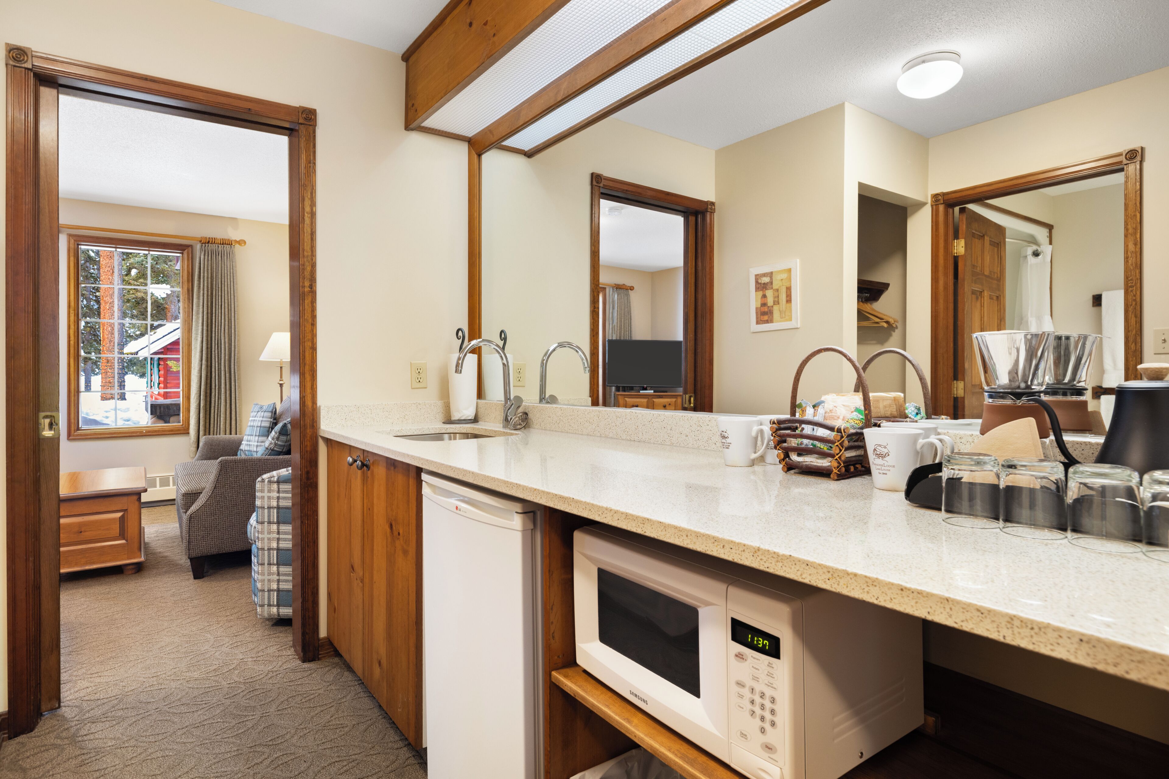 A kitchen with a microwave, sink, and cabinets.