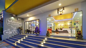 Ein moderner Hotel Eingangsbereich mit freundlichem Willkommensschild, Weihnachtsbaum und Rezeption.