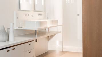 A modern bathroom with a white vanity, double mirrors, and a shower area.