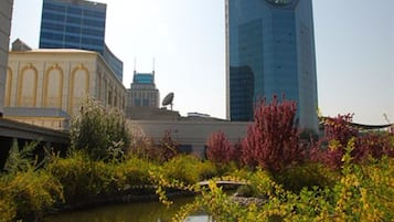 A cityscape with modern buildings, a body of water, and some greenery.
