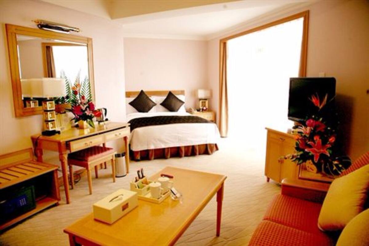 Ein Hotelzimmer mit einem Bett, einem Schreibtisch, einem Fernseher und einem Couchtisch.