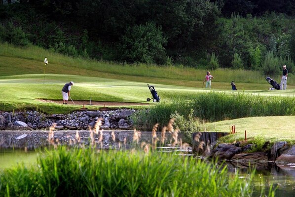 A golf course with a pond, trees, and a clear sky. - Waldsee Golf Resort (Bad Waldsee)