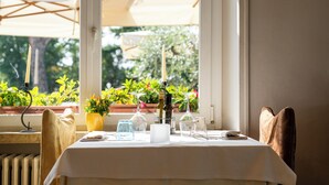 Mesa lista para comer con vistas al exterior, lleno de vegetación.