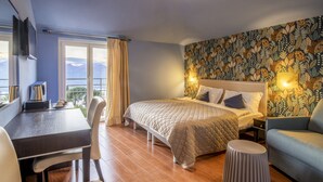 Un dormitorio con cama, escritorio, sillón y sofá.