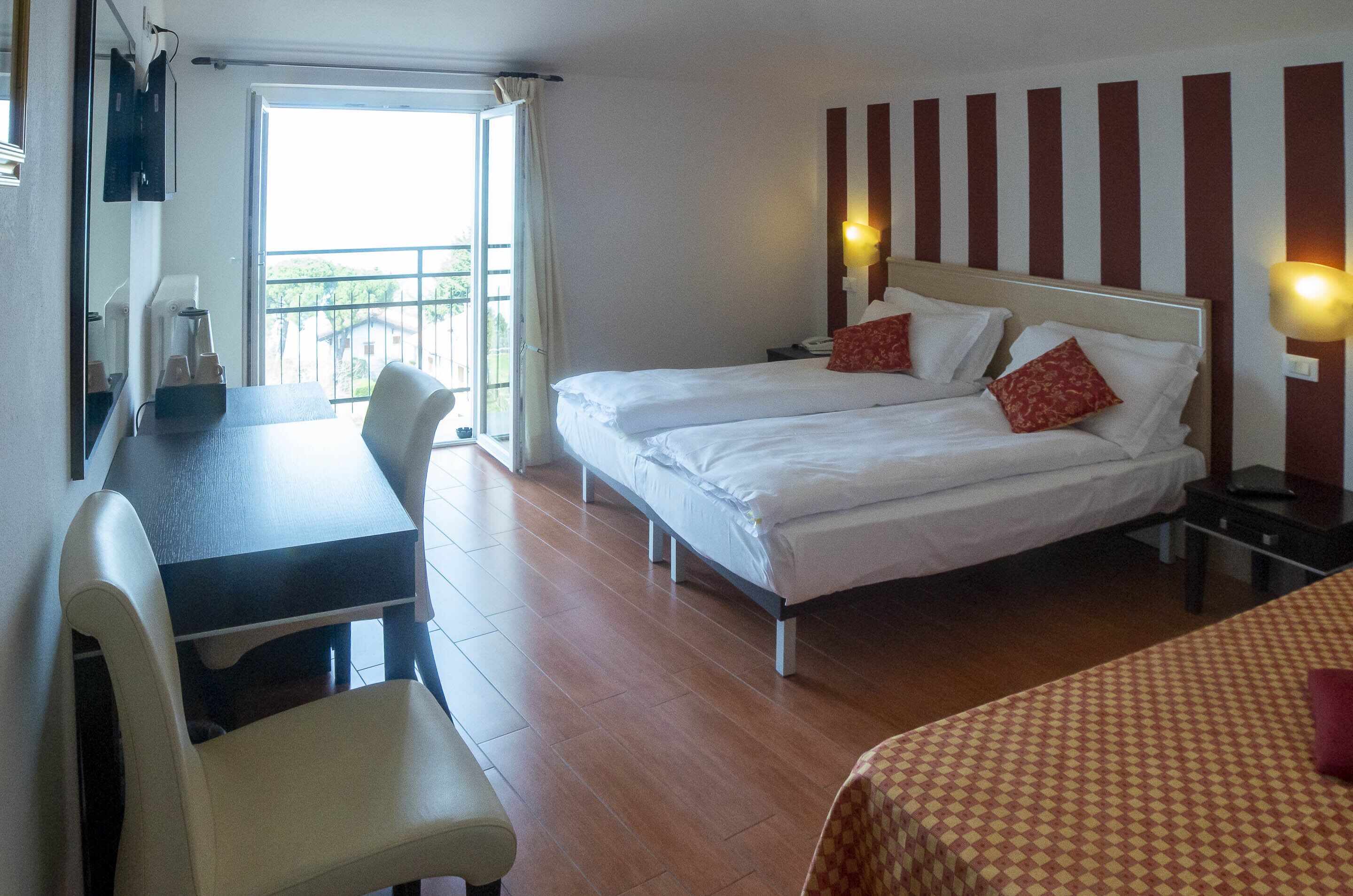 Une chambre d’hôtel avec deux lits, un bureau et une chaise.