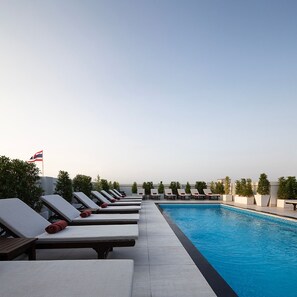 A poolside area with sun loungers and a flag.