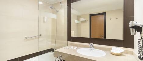 A modern bathroom with a glass shower enclosure, a white sink, and a large mirror.