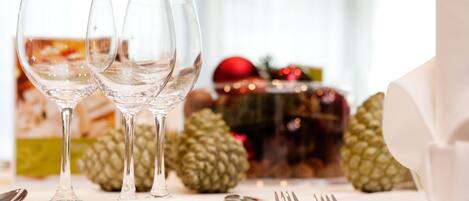 Una mesa servida con copas de vino, cubiertos y una piña.