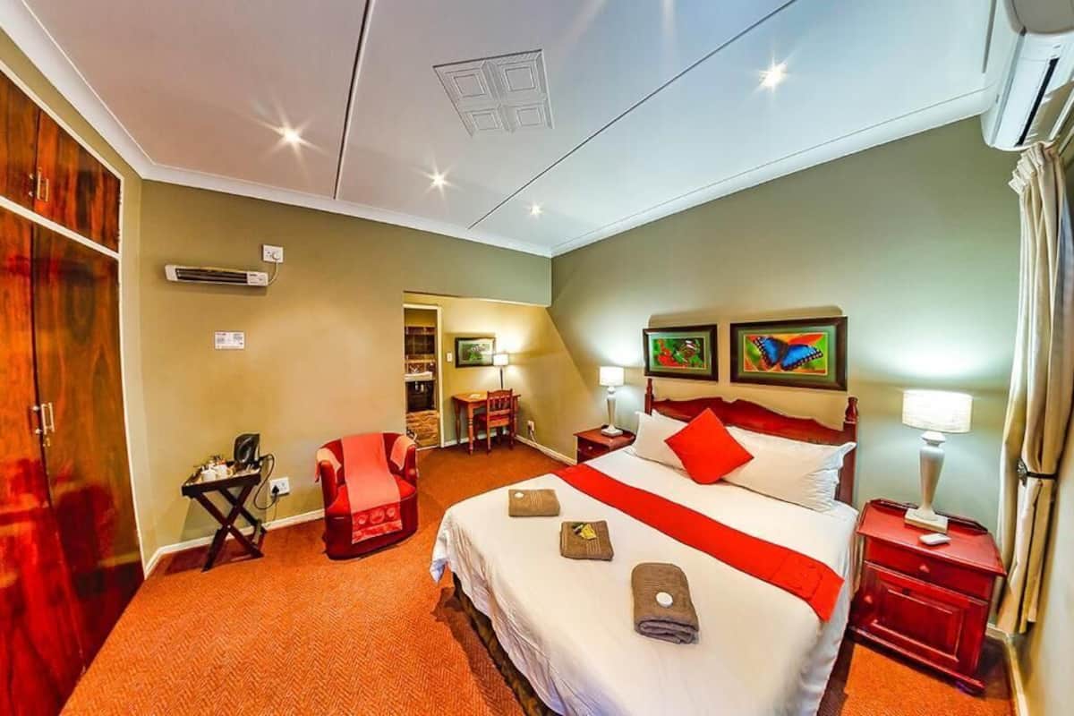 Ein Hotelzimmer mit einem großen Bett, einem Schreibtisch, einem Stuhl und einem Kleiderschrank.