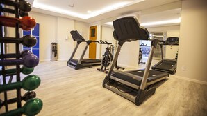 A gym with treadmills, a weight rack, and a mirror reflecting the room. - Intercity Teresopolis (Teresópolis)
