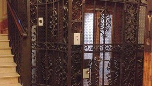 A spiral staircase adjacent to a wrought iron gate with a small window. - Albergo Panorama (Bologna)
