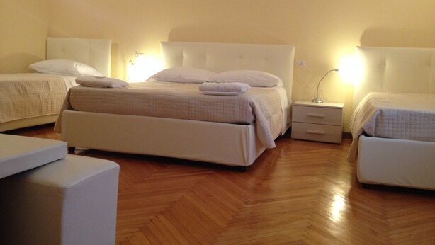 A hotel room with a large bed, two bedside tables, and a small seating area. - Albergo Panorama (Bologna)