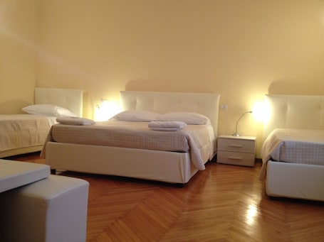 A hotel room with a large bed, two bedside tables, and a small seating area.