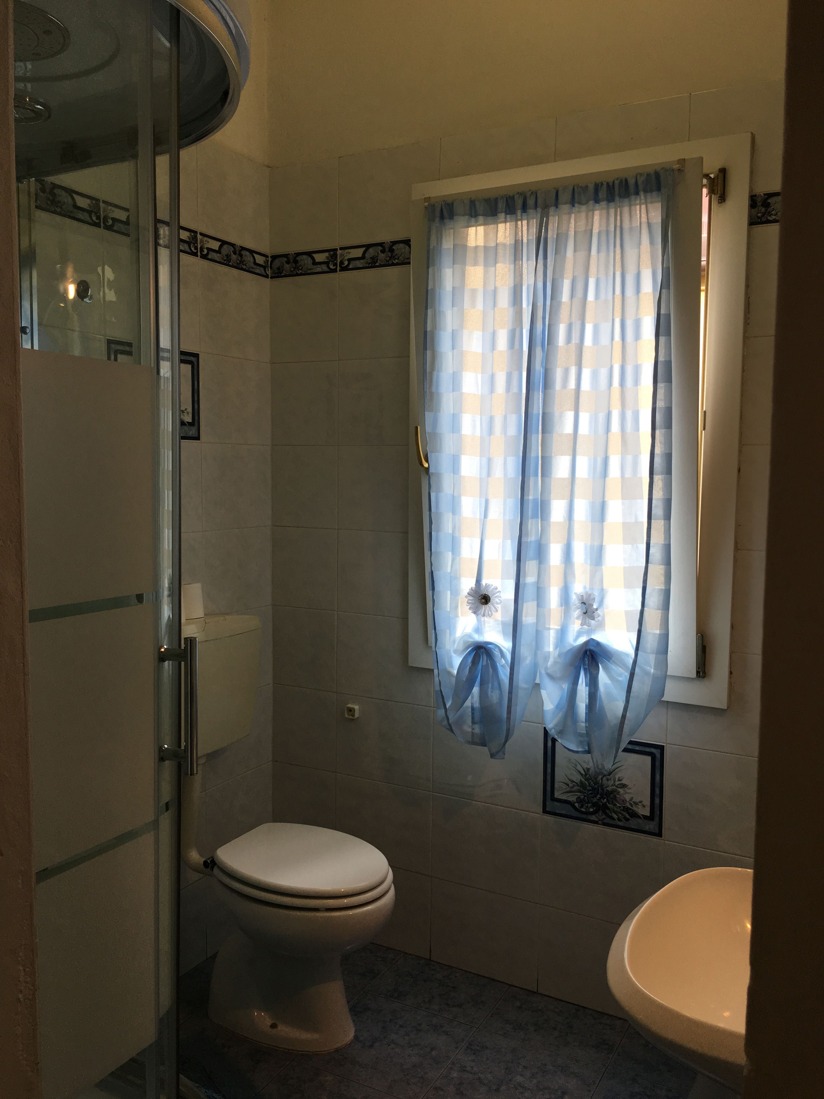 Ein Badezimmer mit Toilette, Waschbecken und Duschbereich.