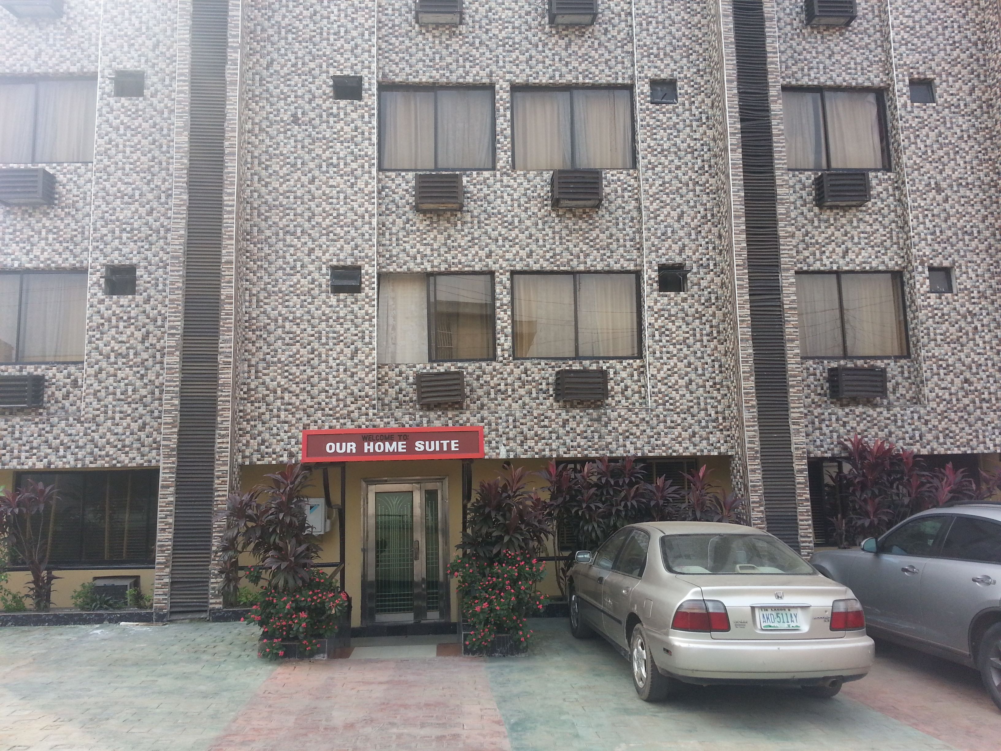 A building with a textured facade and a sign reading "Our Home Suite".