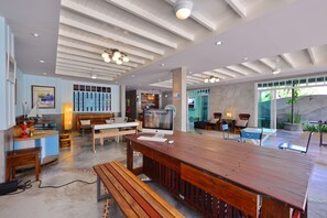 A spacious, modern interior with a wooden bar area, seating arrangements, and a large window providing natural light. - Just Fine Krabi (Krabi)