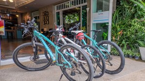 A bike rental area with multiple bicycles, a reception desk, and indoor plants. - Just Fine Krabi (Krabi)