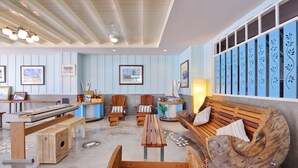 A cozy lounge area with wooden furniture, a piano, and framed artwork on the walls. - Just Fine Krabi (Krabi)