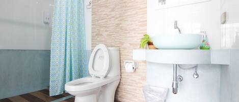 A bathroom with a toilet, a sink, and a shower curtain.