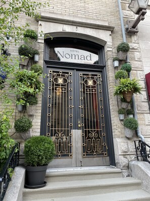 Entrada de un hotel con un cartel que dice "Nomad Hotel".