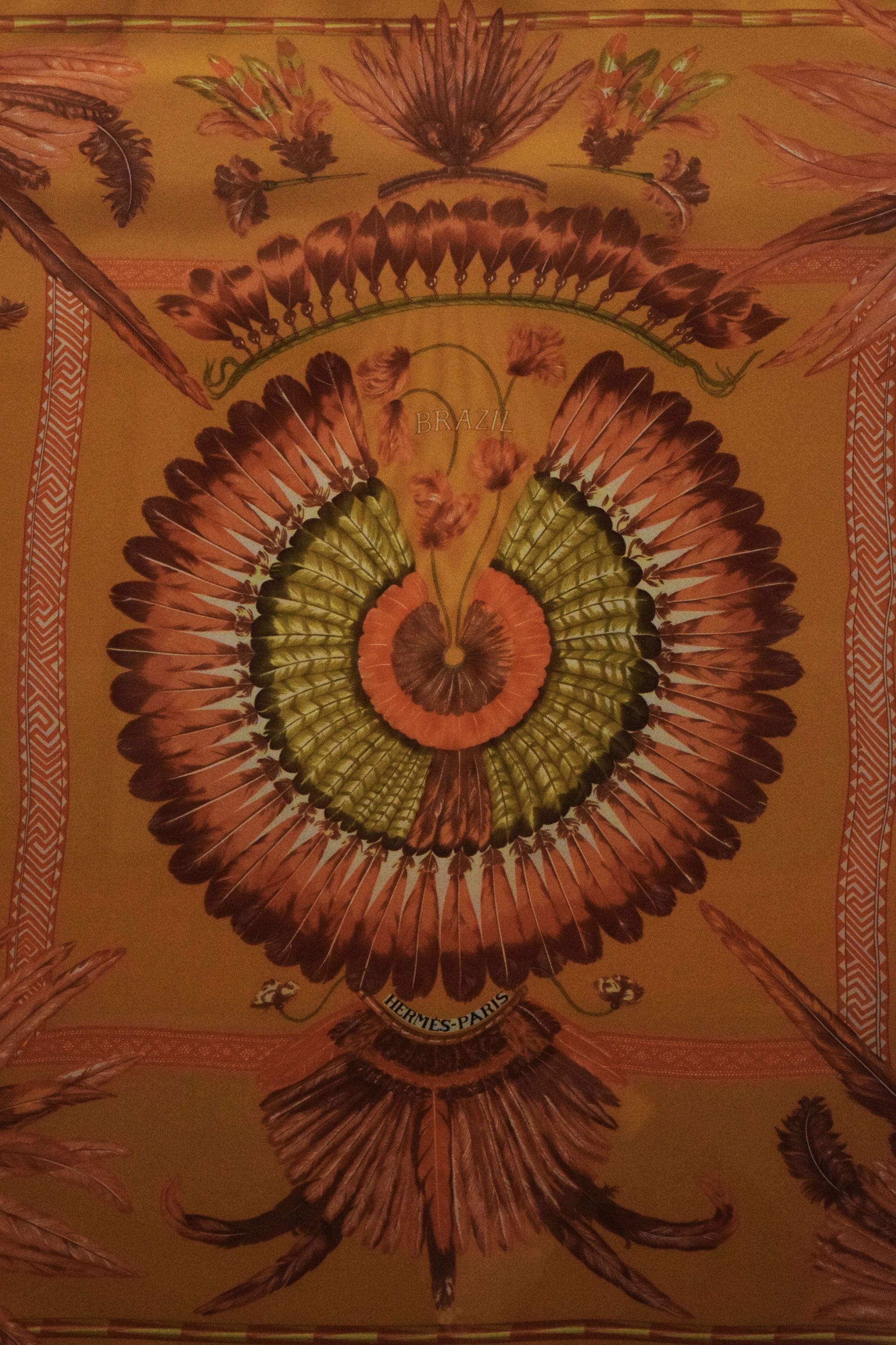A tapestry with a central floral motif and a border with geometric patterns.