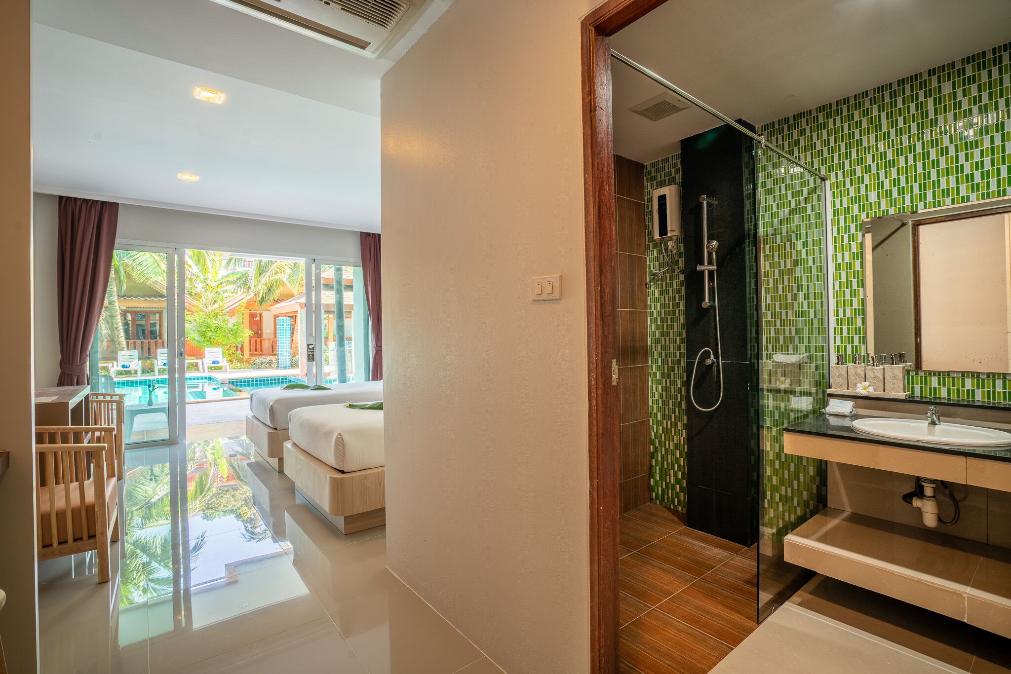 A modern bathroom with a glass shower enclosure, a large mirror, and a sink.