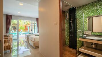 A modern bathroom with a glass shower enclosure, a large mirror, and a sink.