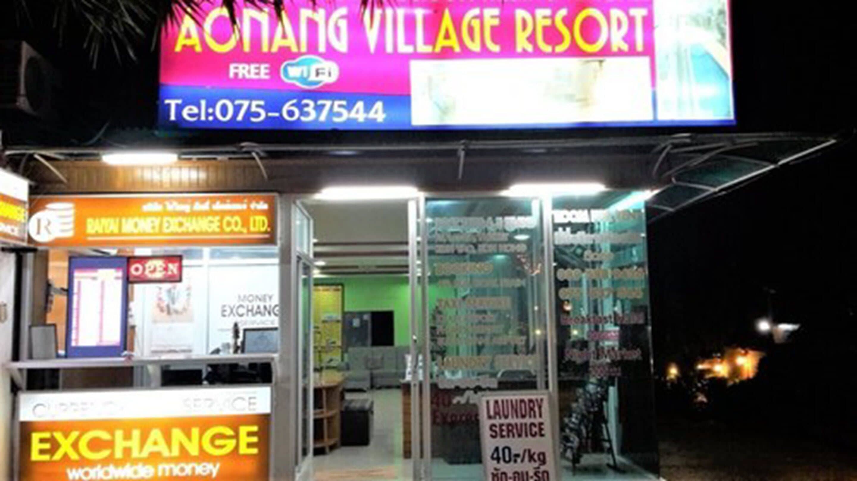 A brightly lit storefront with a sign for 'AONANG VILLAGE RESORT' and a 'FREE Wi-Fi' offer.
